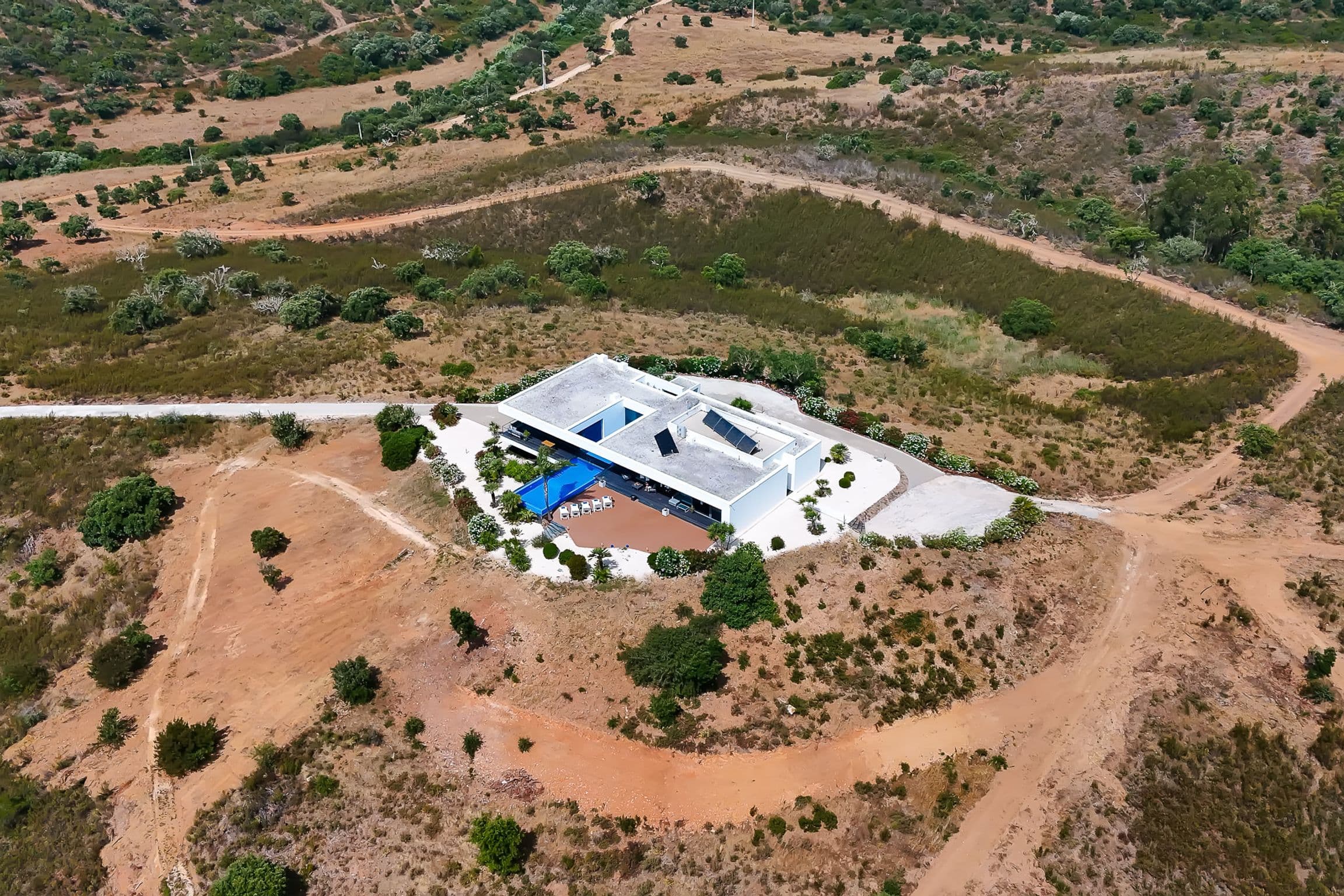 Wide aerial view of the villa on a rise of land surrounded by open countryside