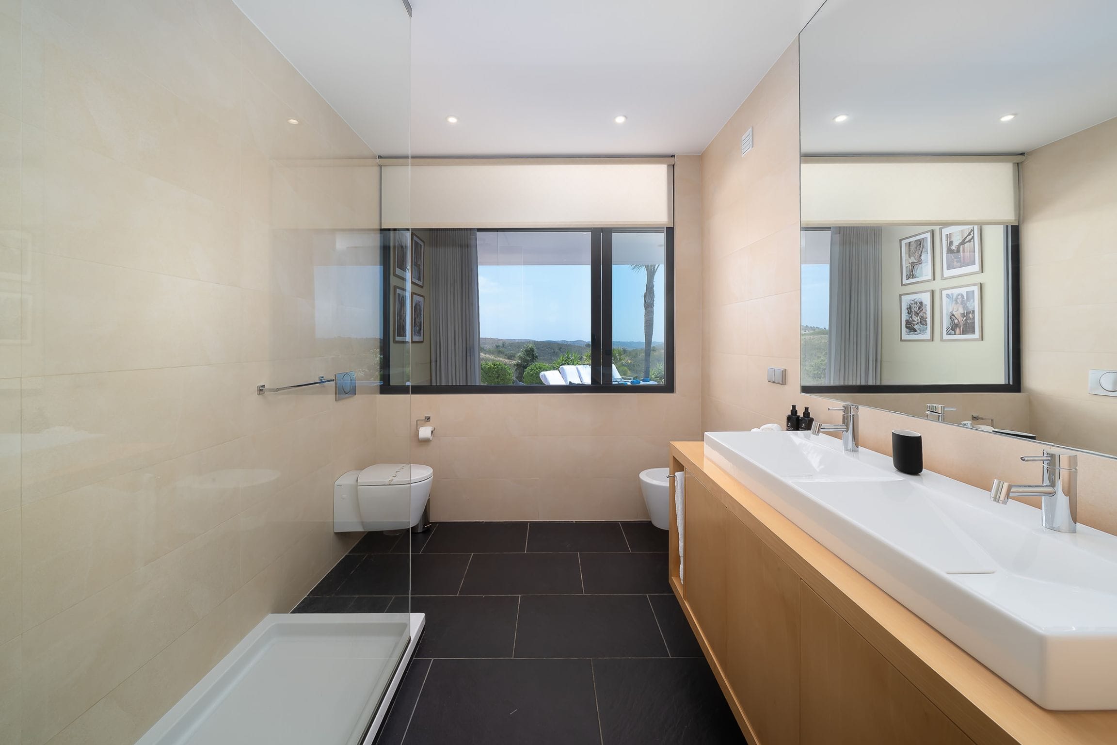 En-suite bathroom with a double basin on a warm timber vanity, walk-in shower and garden window