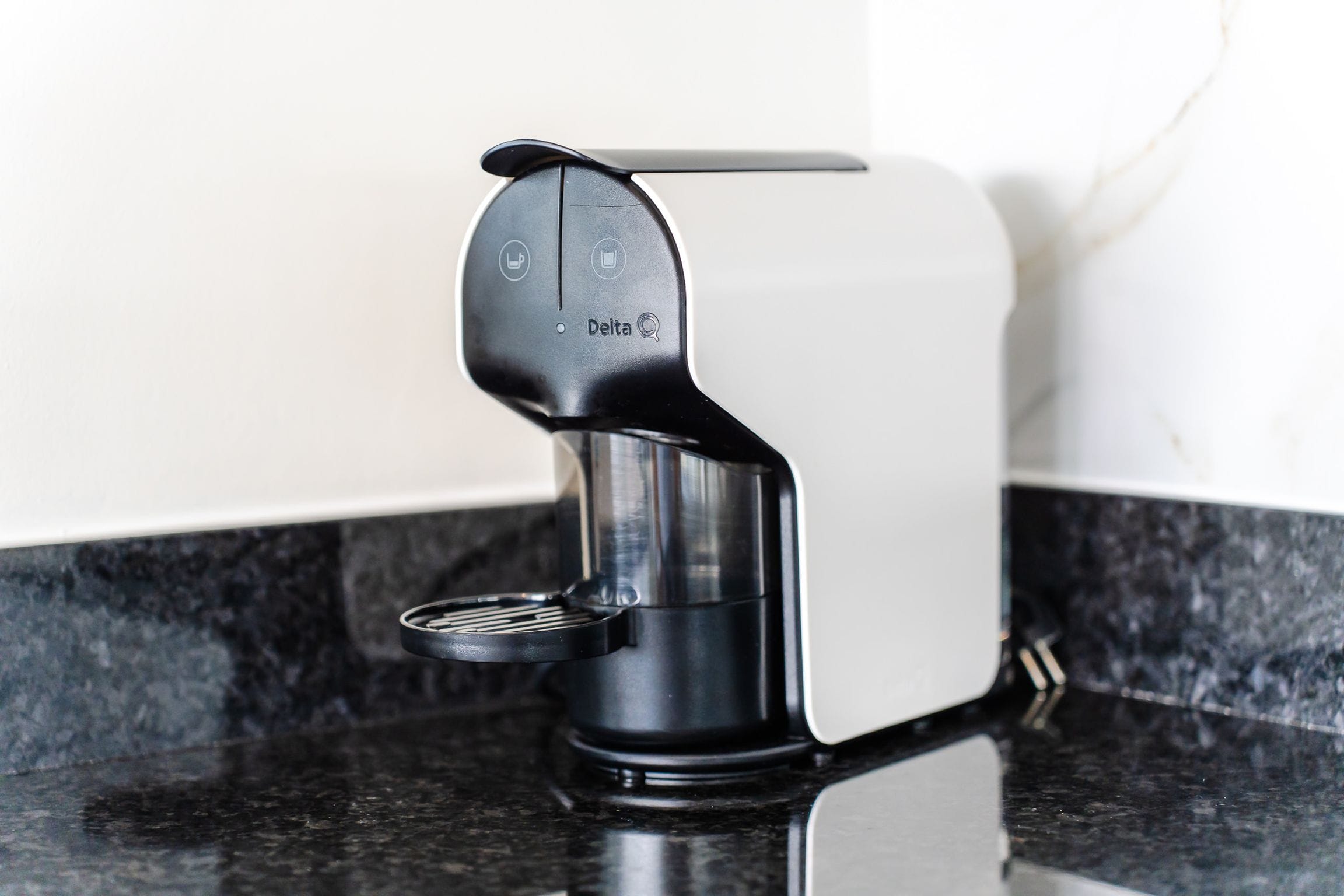 Capsule coffee machine on a black granite worktop