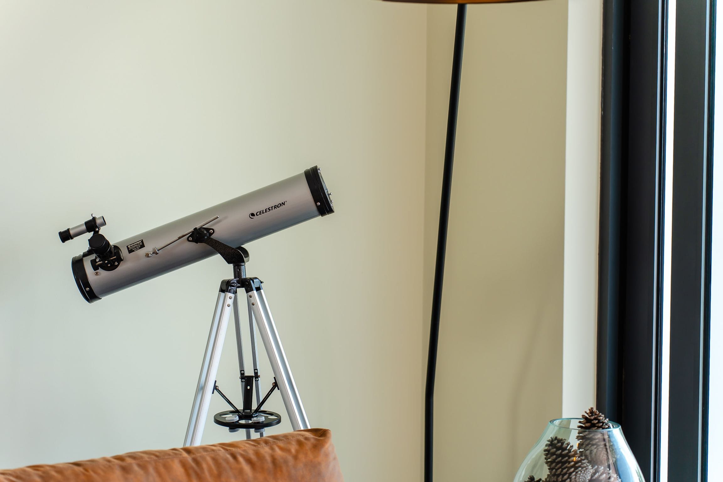 Telescope on a tripod beside a window in the lounge