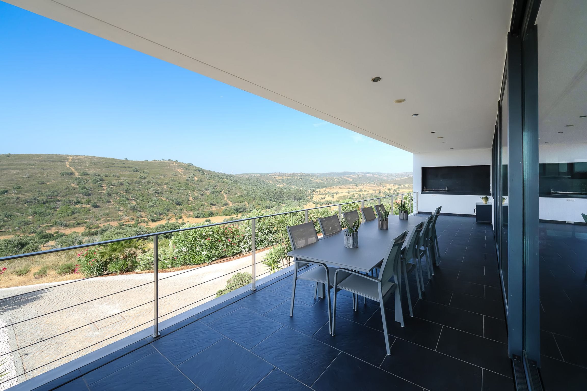 Outdoor dining table on the covered terrace facing a wide valley